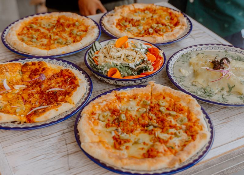 Gourmet pizza toppings arranged on a fresh pizza crust
