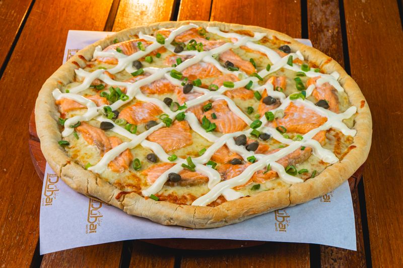 Gourmet salmon pizza on thin artisan pizza crust