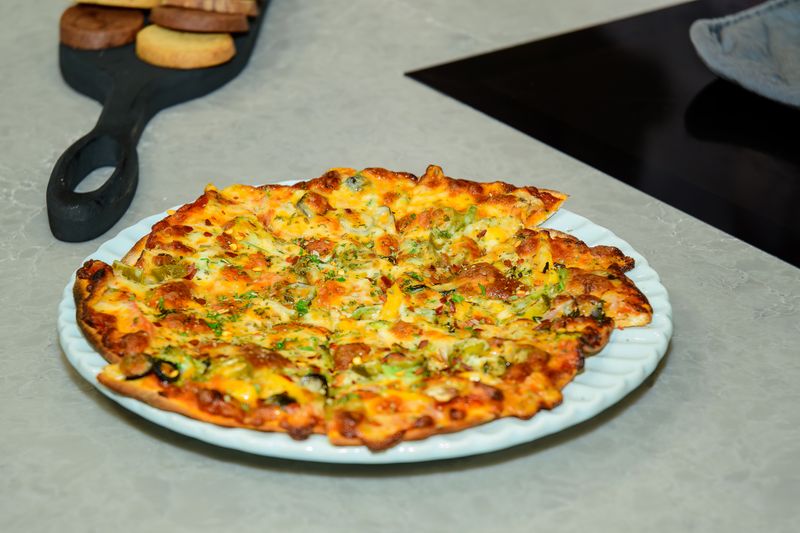 Duck confit gourmet pizza on golden pizza crust